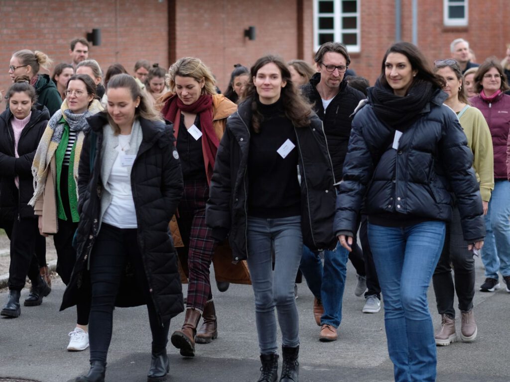 Eine große Gruppe aus Studierenden und dem CSM-Team läuft über den Campus der Leuphana und unterhält sich.