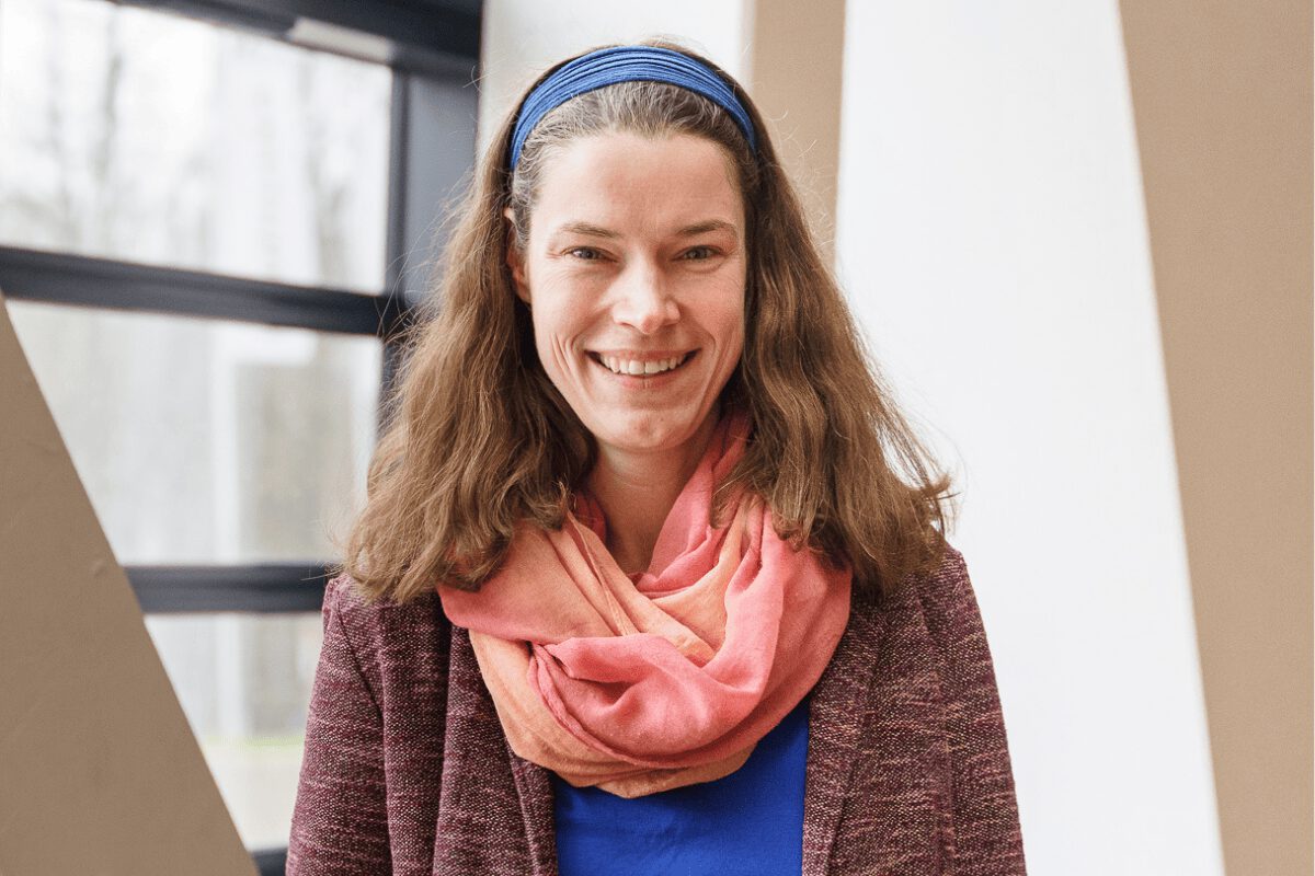 MBA-Absolventin Claudia Kister im Leuphana-Zentralgebäude vor einem Fenster